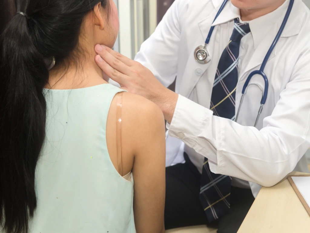 Doctor examining the neck for signs of a salivary gland tumour